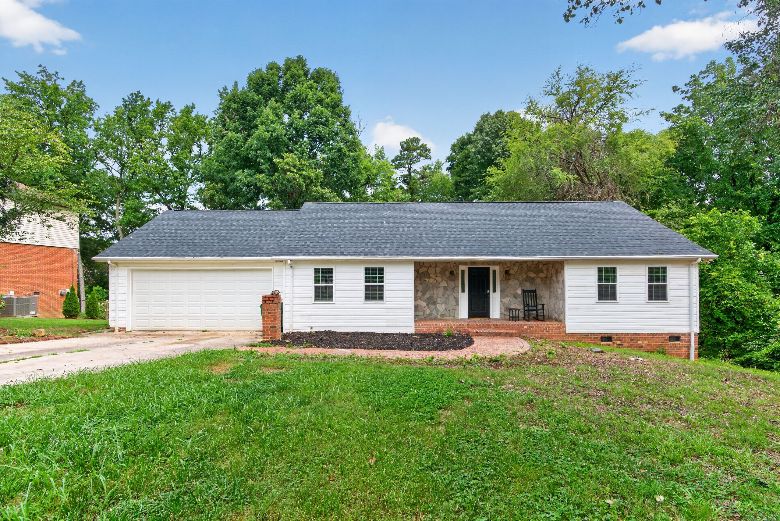 A single-story house with a garage, a front porch, and a well-maintained lawn.
