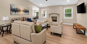 A living room with a fireplace, a sofa, a coffee table, and a television. - Modern Furnished Home Near CLT Airport (Charlotte)