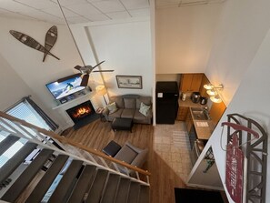 Een moderne woonkamer met een open haard, bank en televisie.