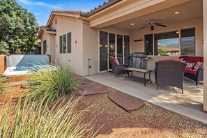 A covered patio area with a hot tub, outdoor furniture, and a ceiling fan. - PV 8: Private Spa, BBQ, Air Hockey & Resort Amenities (Santa Clara)