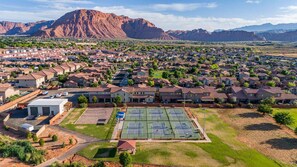 A residential area with houses, a tennis court, and mountains in the background. - PV 8: Private Spa, BBQ, Air Hockey & Resort Amenities (Santa Clara)