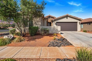 A residential house with a garage, a driveway, and landscaped garden with rocks and shrubs. - PV 8: Private Spa, BBQ, Air Hockey & Resort Amenities (Santa Clara)