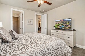A bedroom with a bed, a television on a dresser, and a ceiling fan. - PV 8: Private Spa, BBQ, Air Hockey & Resort Amenities (Santa Clara)