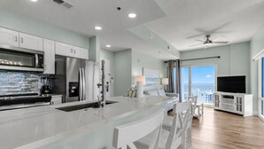 A modern kitchen with a central island, white cabinetry, and stainless steel appliances. - 10th-Floor Luau Condo | Fabulous South-Facing Gulf Views & Beach Access (Miramar Beach)