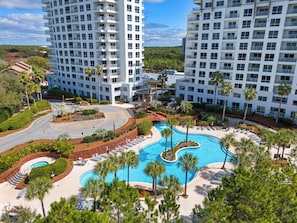 A resort with a pool, palm trees, and high-rise buildings. - NEW !!! Luau 2–7034 | 10th-Floor Studio, 2 Queens,  south facing Gulf Views, Pool & Beach Tram (Miramar Beach)