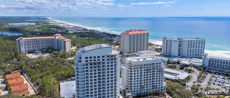 A resort with multiple high-rise buildings, a swimming pool, and a beach view.