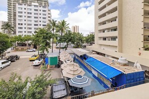 Ein Hotel mit Poolbereich, mehreren Etagen und einem Parkplatz mit Autos.