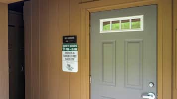A door with a sign indicating quiet hours and a smoke-free facility.