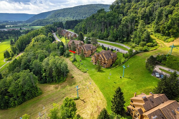 A residential area with multiple two-story buildings, a road, and a ski lift.