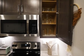A kitchen with stainless steel appliances, including a microwave and an oven. - Cozy 1-bedroom apartment in gorgeous The Woodlands with AC (The Woodlands)