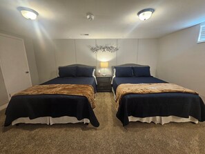 Ein Hotelzimmer mit zwei Betten, einem Nachttisch, einer Lampe und einer Deckenleuchte.