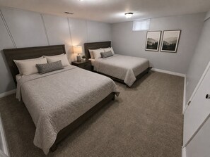 A bedroom with two beds, a nightstand with a lamp, and two framed pictures on the wall. - En-Tice-ing 1 Bd Getaway Sandy Ut Mtns Ski & I-15 (Sandy)
