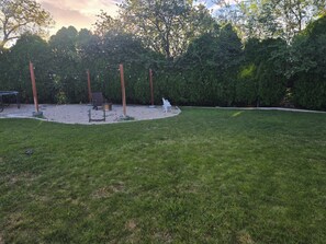 A backyard with a grassy lawn, a metal table, and a bench. - En-Tice-ing 1 Bd Getaway Sandy Ut Mtns Ski & I-15 (Sandy)