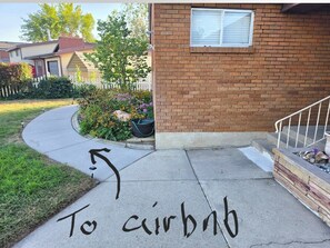 A residential driveway with a house, a white picket fence, and a brick wall. - En-Tice-ing 1 Bd Getaway Sandy Ut Mtns Ski & I-15 (Sandy)