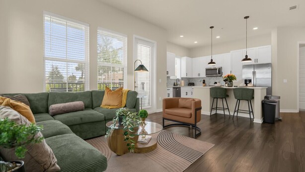 A modern living room with a sectional sofa, a small round coffee table, and a bar area with stools. - Luxury Retreat, Close to Disney (Winter Garden)