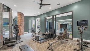 A gym with exercise equipment, a large mirror, and a ceiling fan. - Luxury Retreat, Close to Disney (Winter Garden)
