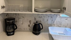 A kitchen with white cabinets, a coffee maker, a kettle, and a dish rack. - Luxury Retreat, Close to Disney (Winter Garden)