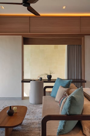 A modern living room with a sofa, coffee table, and a ceiling fan.