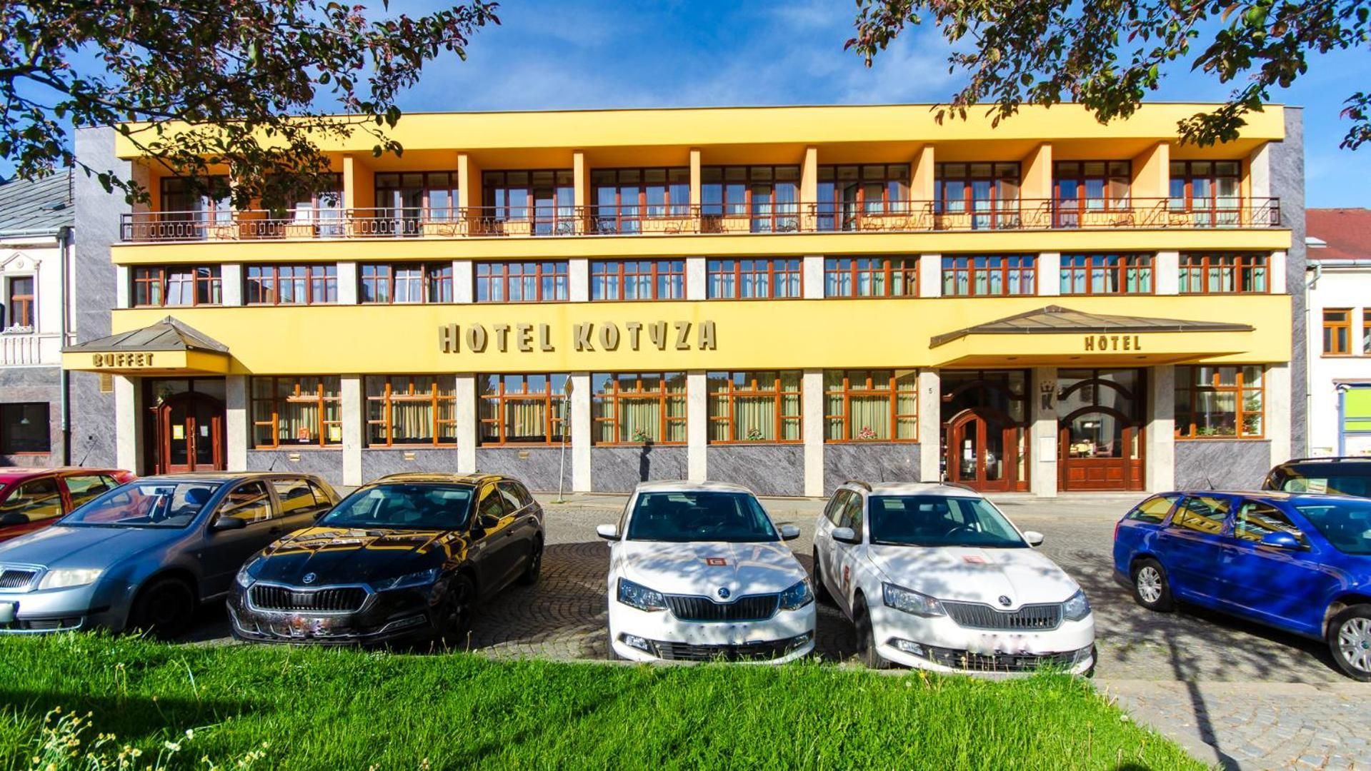 Un hotel con fachada amarilla, varios balcones y un bufé.