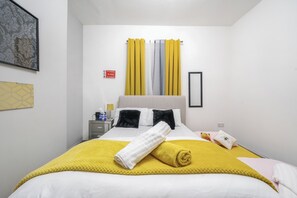 A hotel room with a bed, a nightstand, a lamp, and a teddy bear. - Contractor friendly home with free parking (Stoke-on-Trent)