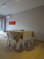 Un comedor con una mesa y sillas, un sofá y una ventana con cortinas.