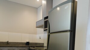 Una cocina moderna con electrodomésticos de acero inoxidable, un microondas y un horno empotrado.