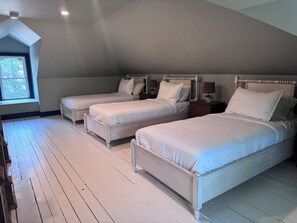 A bedroom with three beds, a window, and a ceiling light. - Downtown Mystic Getaway - Porch, Yard & Bunk Room (Mystic)