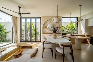 Un espacio habitable moderno con comedor, asientos y cocina.
