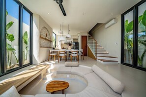 Un espace de vie moderne comprenant une cuisine, un coin repas et un escalier.