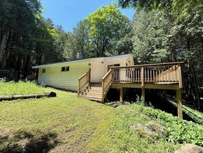 A mobile home with a wooden deck and a ramp leading to the entrance.