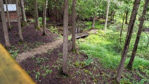 A forested area with a wooden bridge and a signpost. - Hidden River Retreat | Secluded Riverfront Cottage (Markdale)