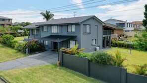 A two-story residential house with a covered driveway, a fenced yard, and a satellite dish. - Rennies Sands | A Surfer's Dream by Rennies Beach (Ulladulla)