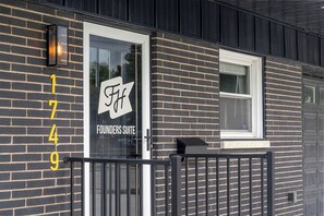 A building with a glass door labeled 'Founders Suite' and a black metal fence.