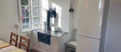 A compact kitchen with a refrigerator, a sink, and a window.