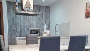 Un comedor moderno con una mesa de madera y sillas tapizadas en gris.