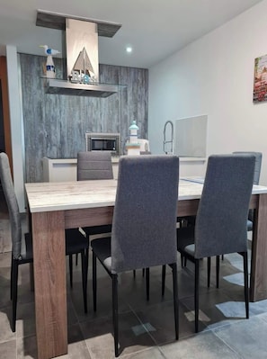 A modern dining area with a wooden table and grey upholstered chairs. - Tenerife Paradise With Heated Pool (ADEJE)
