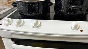 En Zanussi ovn med hvid facade, to styreknopper og en glasdør.