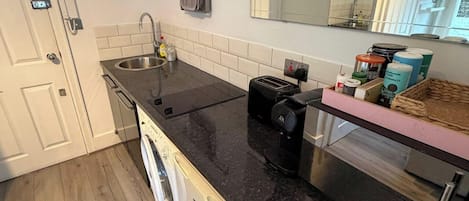 A modern kitchen with a built-in dishwasher, a coffee maker, and a toaster.
