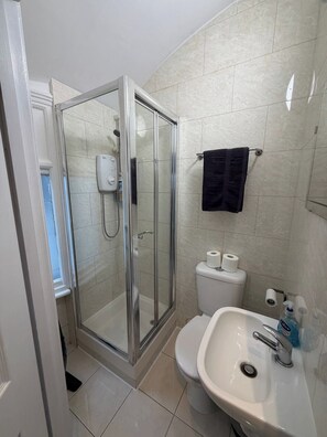 A bathroom with a glass-enclosed shower, a toilet, a sink, and a towel rack. - Studio Sleeps 2 with WiFi (London)
