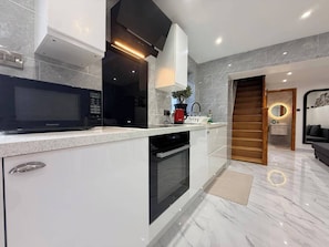 A modern kitchen with a microwave, oven, and sink. - Brand New! (Cardiff)