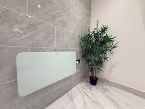 A bathroom with a glass shower enclosure, a potted bamboo plant, and marble flooring. - Brand New! (Cardiff)