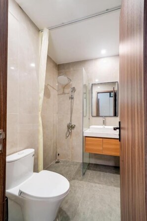 Un baño con inodoro, ducha y lavamanos.