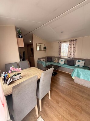 A compact living space with a dining area, a sofa set, and a kitchenette.