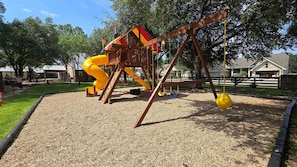 Ein Spielplatz mit Rutsche und Schaukeln.
