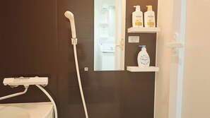 Comfort vierpersoonskamer | Badkamer | Een bad/douchecombinatie, een haardroger, handdoeken, zeep