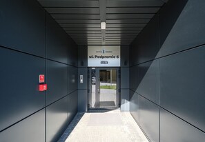 An elevator entrance with a sign indicating 'ul. Podpromie 6' and a fire alarm on the wall. - Podpromie Modern Apartment (Rzeszów)