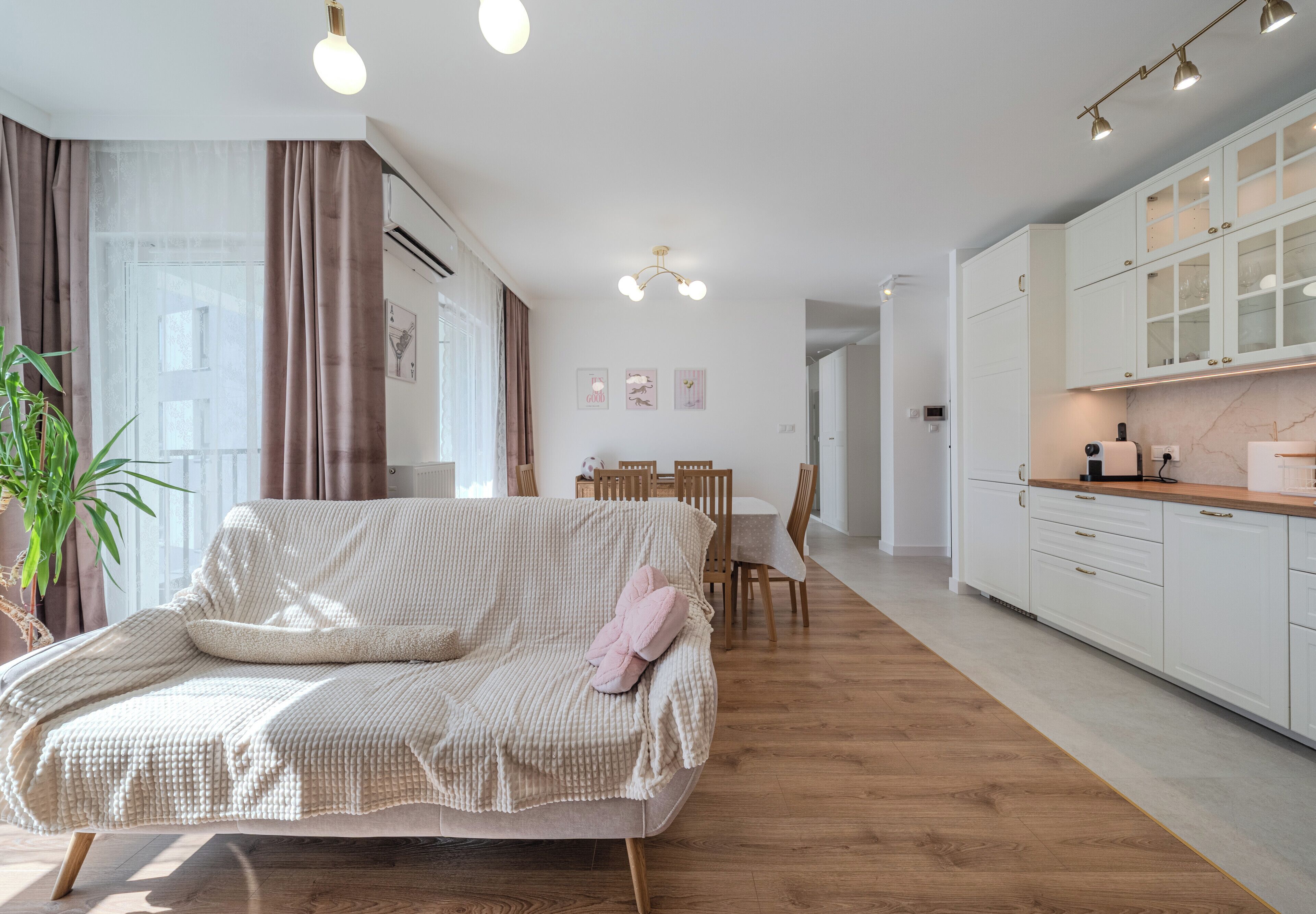 Una sala de estar moderna con sofá, mesa de comedor y área de cocina.
