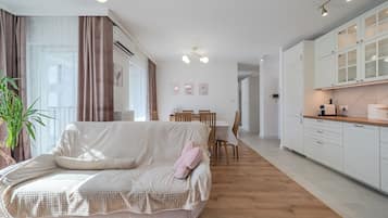 Una sala de estar moderna con sofá, mesa de comedor y área de cocina.