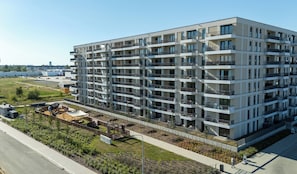 A multi-story residential building with balconies, a landscaped garden area, and a paved walkway. - Ciesielskiego Glamour Apartment (Kraków)