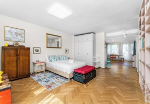 A well-lit bedroom with a bed, wardrobe, and a desk area. - Retoryka Old Town Colorful Studio (Kraków)